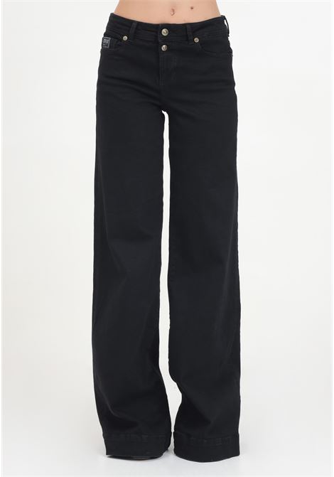 Jeans a vita bassa svasati neri da donna con logo in stile gotico VERSACE JEANS COUTURE | 77HAB506CDW00909